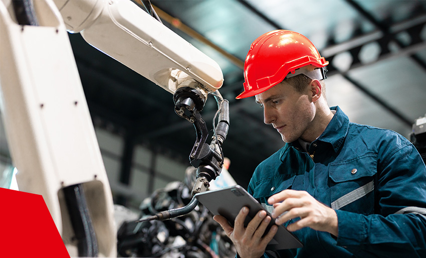 Medewerker in een fabriek bij een Datagroup-machine met bedieningstablet Medewerker in een fabriek bij een Datagroup-machine met bedieningstablet